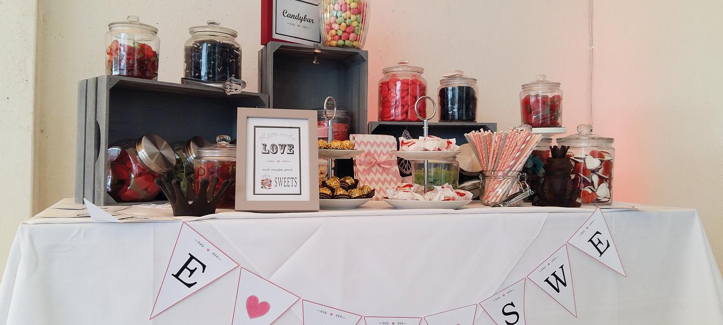 Bunt bestückte Candy Bar auf einem Tisch mit weißer Tischdecke