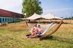 Urlaubsgäste genießen ihr Eis in der Hängematte vor dem Freetent.