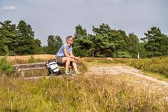 Urlaubsgast macht Pause während einer Wanderung in der Lüneburger Heide.