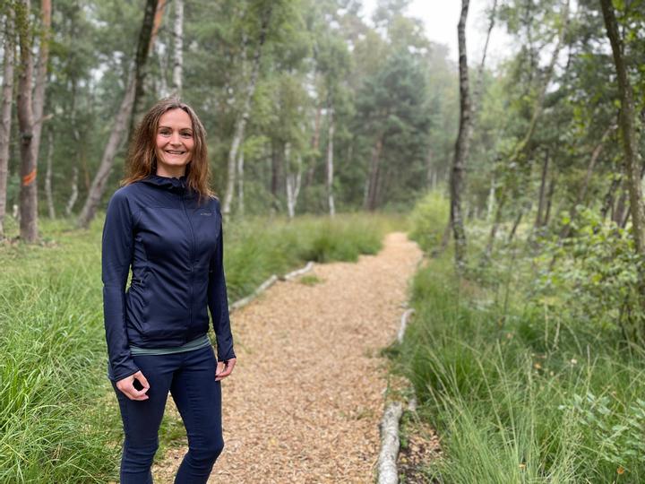 Eine Frau in Sportkleidung geht durch den Wald