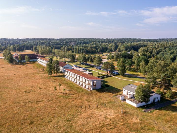 Luftbild mit Hotelgebäuden, Wald und offener Landschaft