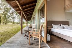 Ebenerdiges Hotelzimmer mit Holzterrasse und Gartenmöbel