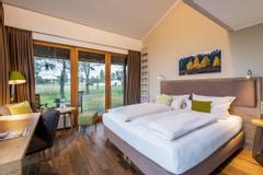 otelzimmer mit Doppelbett und großer Fensterfront mit gemütlicher Stimmung